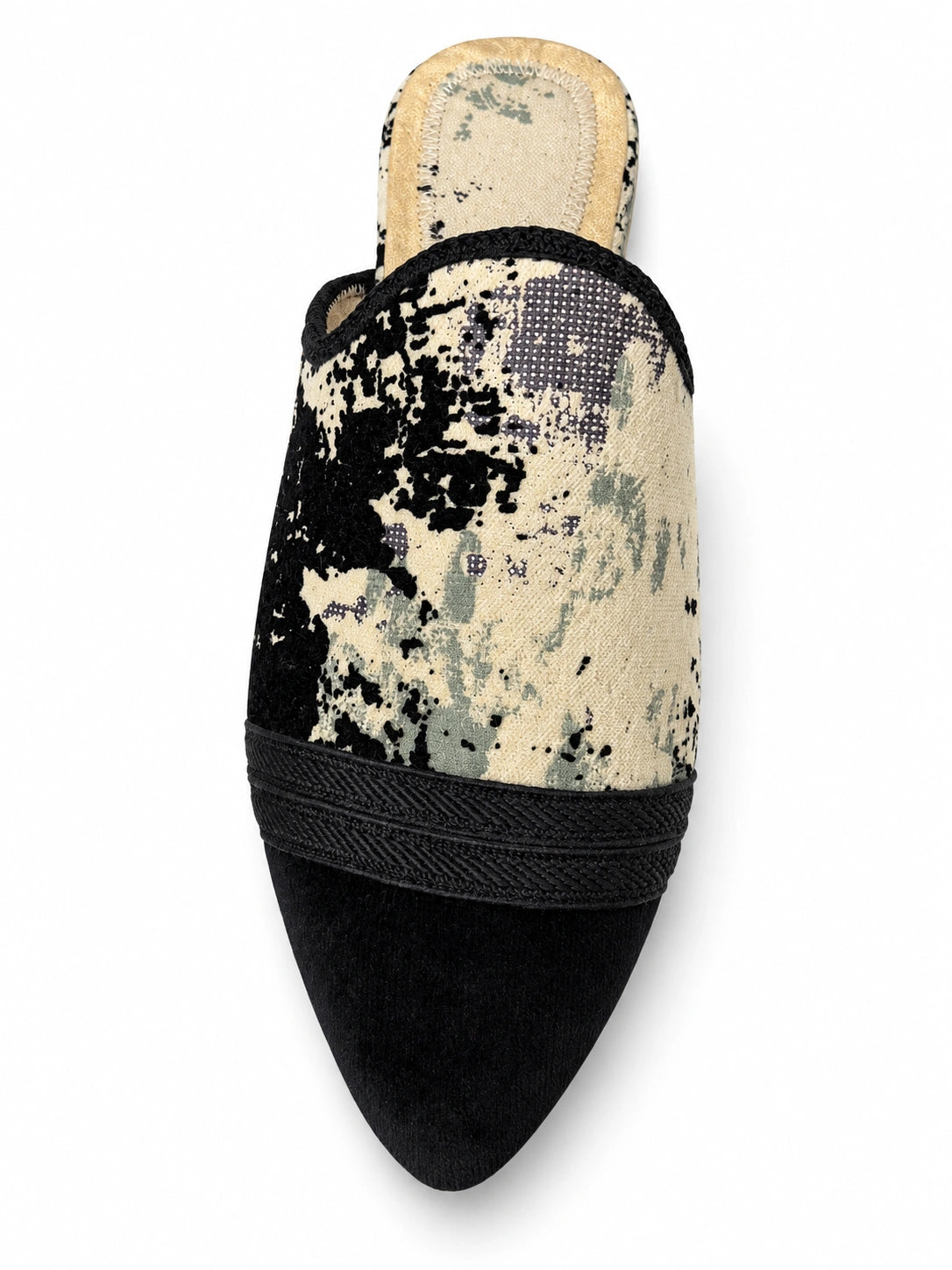 Black and cream abstract-pattern babouche with black braided front bands and a plain black pointed toe, shown on white.
