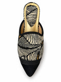 Black and cream leaf-pattern babouche with black pointed toe, braided front band and gold-tone footbed, shown on white.