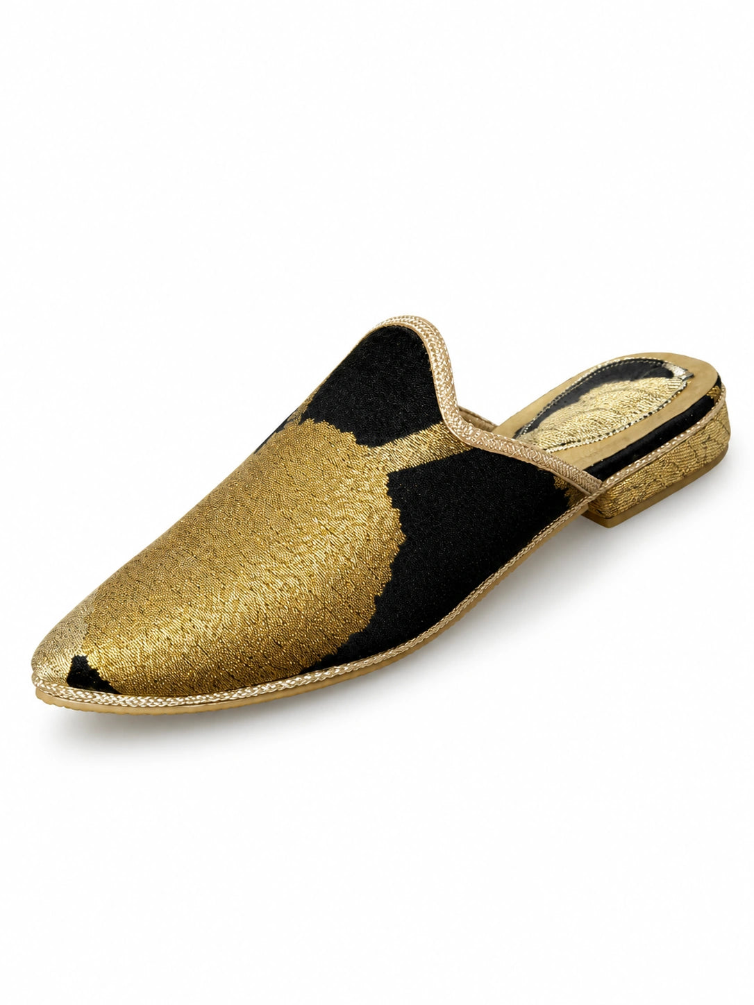 Black and gold-tone babouches with an asymmetric abstract pattern across the pointed upper, on a white background.