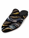 Black babouche with gold, silver-grey, teal and blue embroidered waves and rows of gold sequins on white.