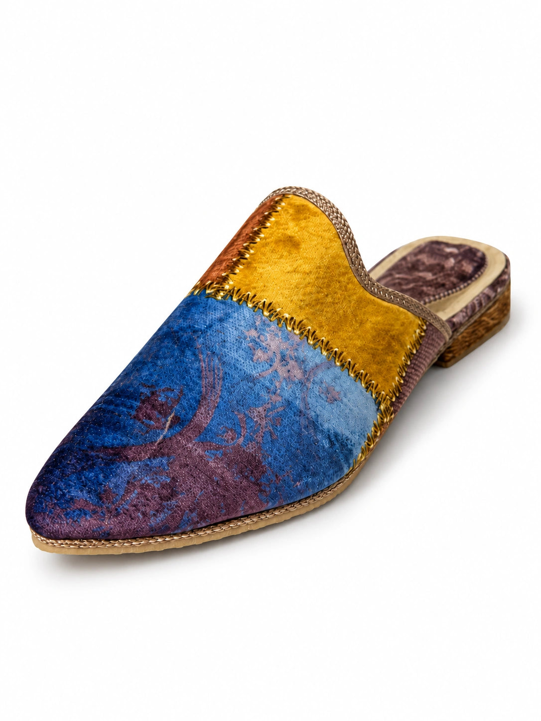 Blue and plum abstract babouche with a mustard-gold panel, decorative zigzag stitching and braided edging on white.