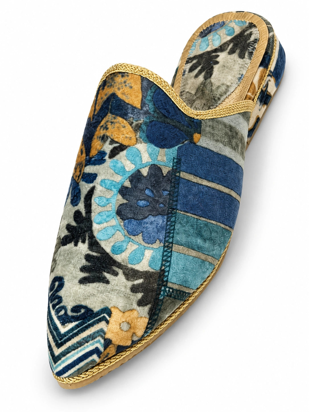 Blue and green patterned babouche with floral motifs, geometric blocks and gold-tone braided edging on a white background.