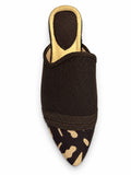 Dark brown babouche with beige spots at the pointed toe and a tonal braided band on a white background.