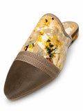 Babouche with a yellow and cream abstract floral upper, brown pointed toe and taupe braided trim on white.