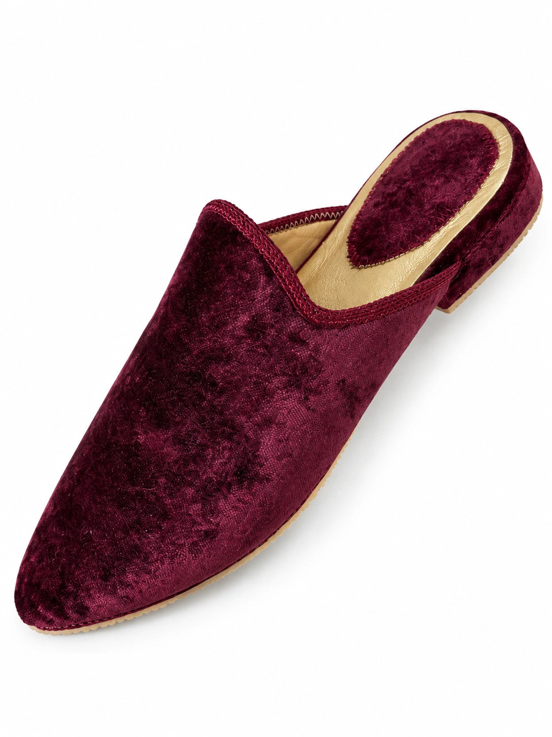 Burgundy babouche with a mottled velvet-like texture, tonal braided trim and a gold-tone heel rim on white.