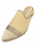 Cream woven babouche with a pale gold-tone pointed toe, metallic braided band and open back on white.