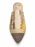 Cream babouche with grey and mustard streaks, a plain grey pointed toe and two gold-tone braided bands on a white background.
