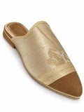 Pale gold-tone babouche with a brown pointed toe, braided dividing band and open back on white.