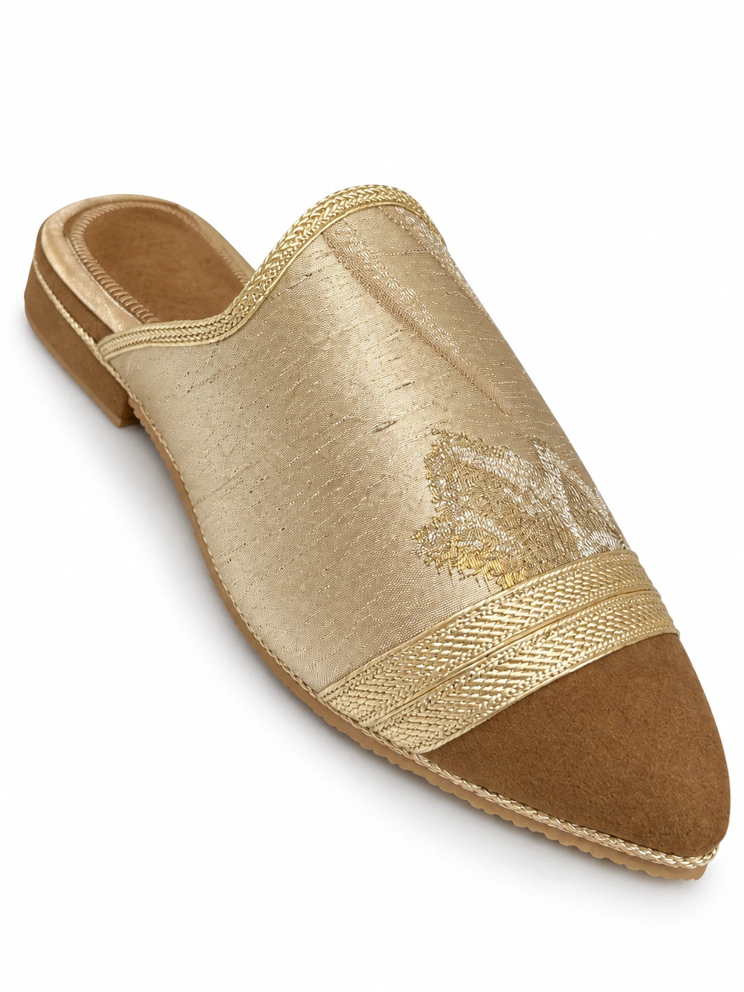 Pale gold-tone babouche with a brown pointed toe, braided dividing band and open back on white.
