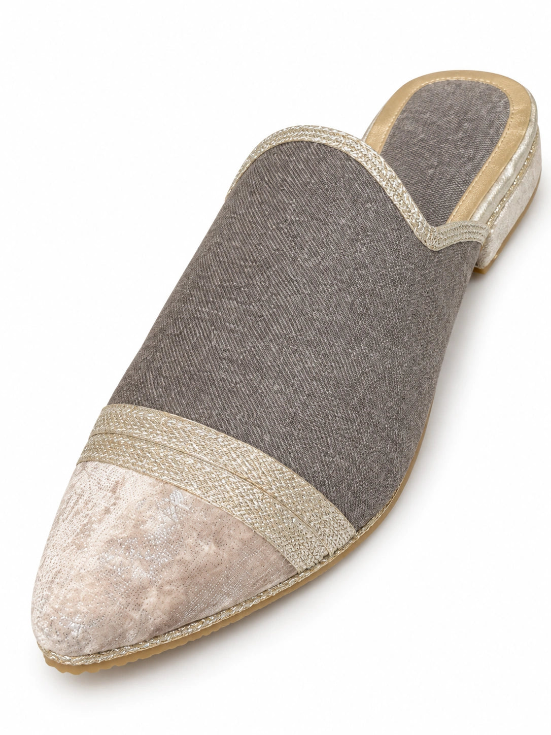 Grey babouche with a pale patterned pointed toe, light metallic braided band and open back on a white background.