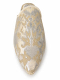 Front view of an ivory babouche with pale gold and silver-grey floral motifs and light braided edging on a white background.