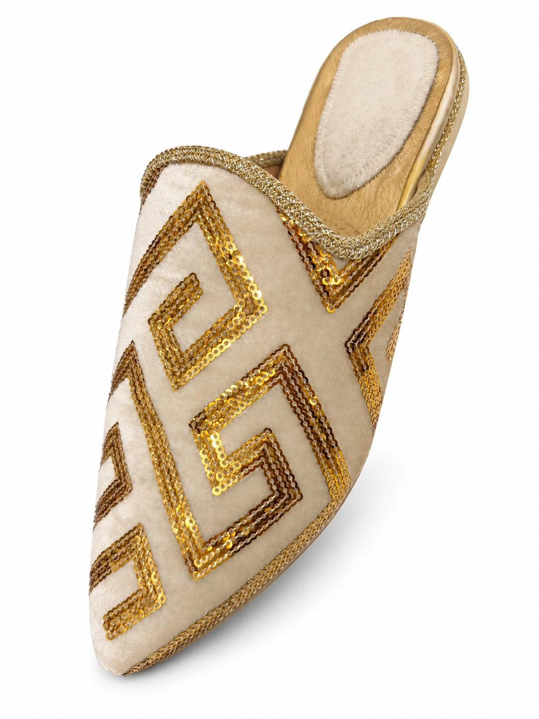 Ivory babouche with gold geometric sequin motifs and braided edging on a white background.