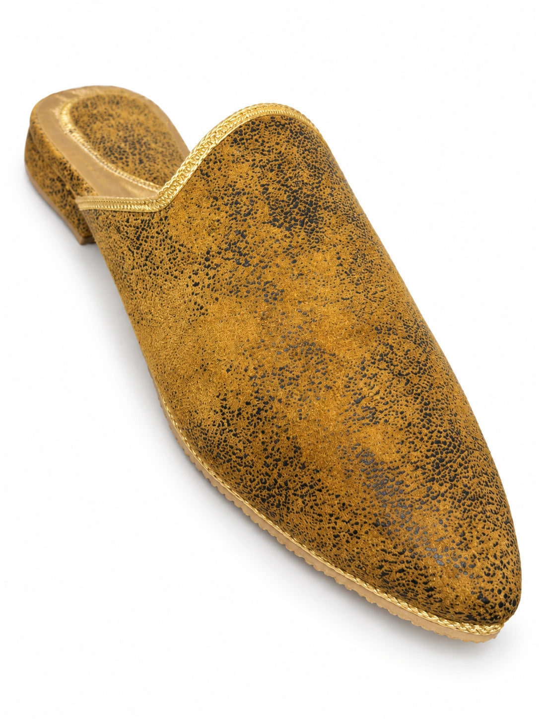 Ochre pointed-toe babouche with dark mottled markings and gold-tone edging, isolated on white.