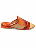 Side view of an orange, burgundy and taupe patterned babouche with a pale gold toe and orange braided band on white.