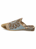 Side view of a pale blue babouche with brown ornamental motifs, a gold-tone toe and braided trim on a white background.