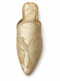 Pale gold floral-pattern babouche with gold-tone braided edging and a pointed toe, shown on white.
