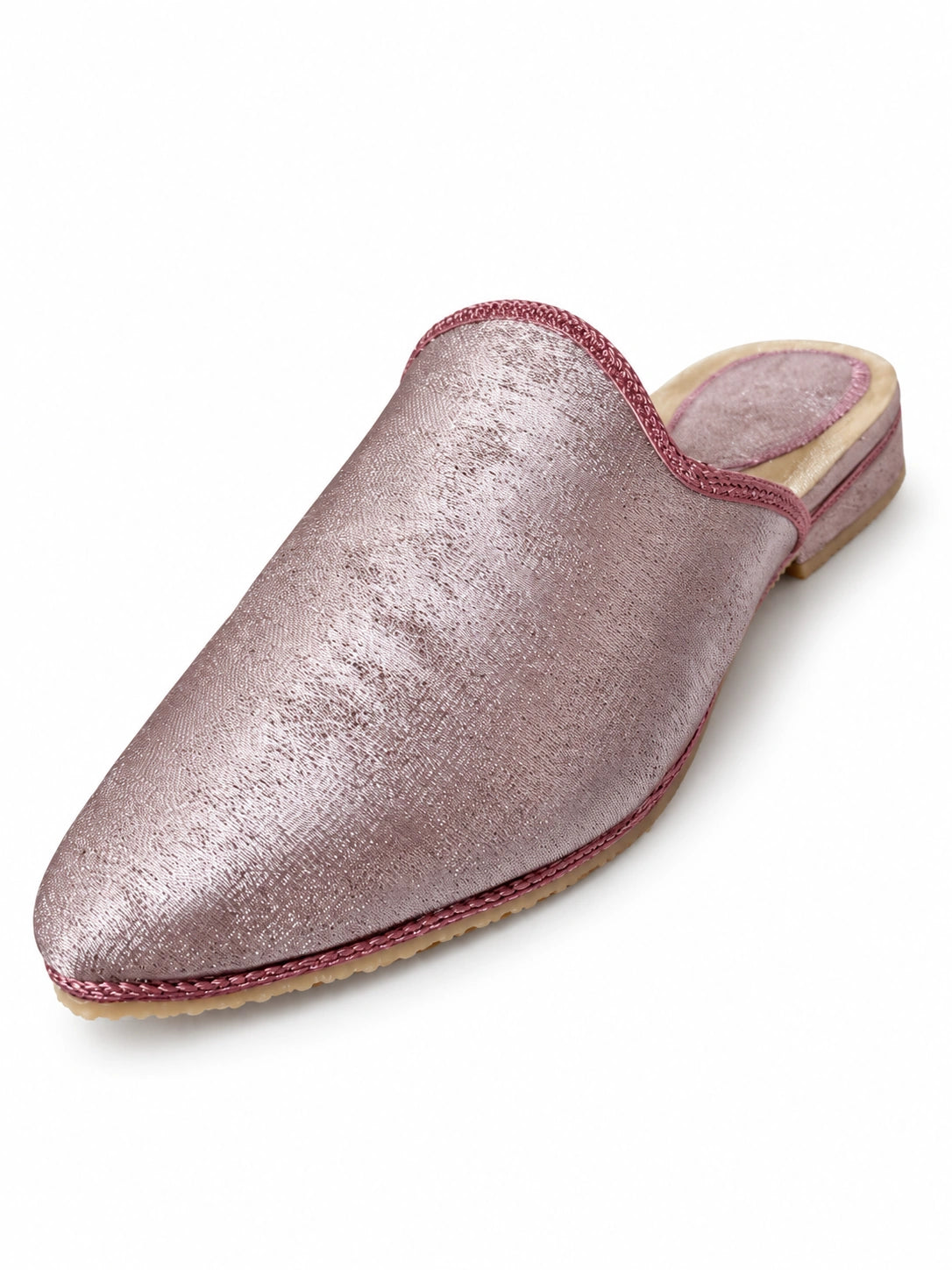 Pale pink shimmering babouche with dusty rose braided trim, a low covered heel and gold-tone heel rim on white.