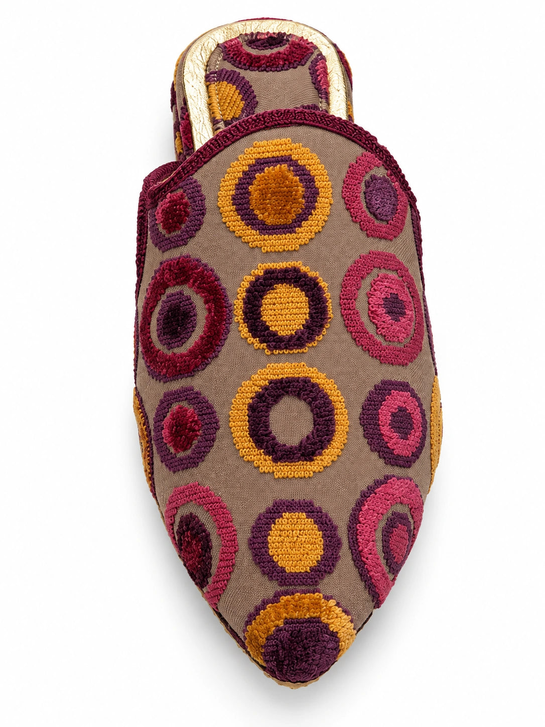 Taupe babouche with raised pink, burgundy and mustard-gold circle motifs and burgundy trim on a white background.