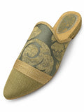 Sage green babouche with gold-tone floral scrolls, a braided front band and an olive-gold pointed toe, shown on white.