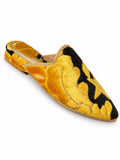 Golden-yellow and black babouches with large ornamental motifs and a plush textured surface, on a white background.