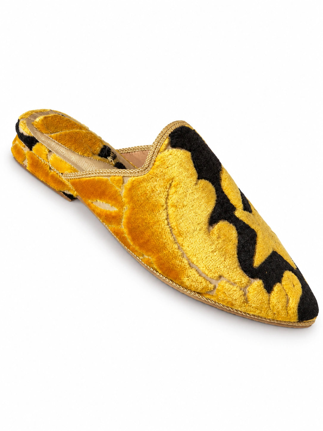 Golden-yellow and black babouches with large ornamental motifs and a plush textured surface, on a white background.